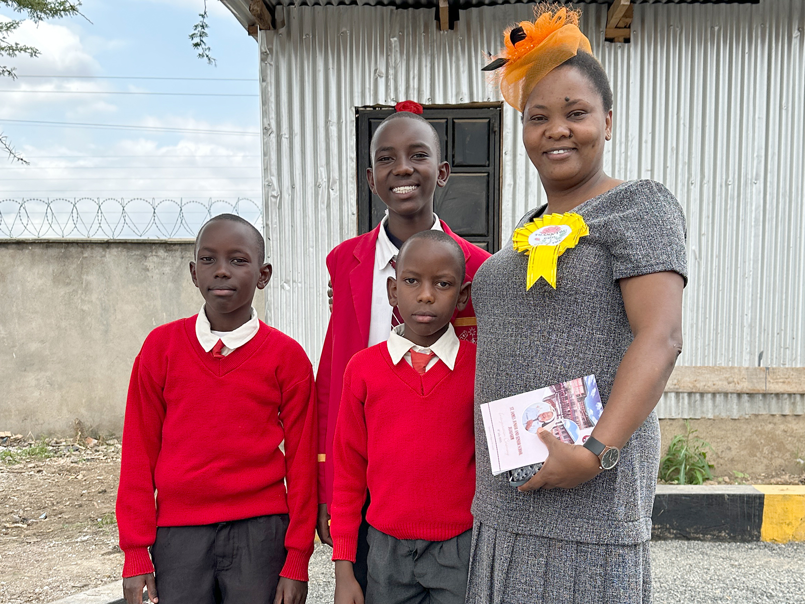 Stolze Mutter mir Ihren drei Kindern, die bereits hier zur Schule gehen